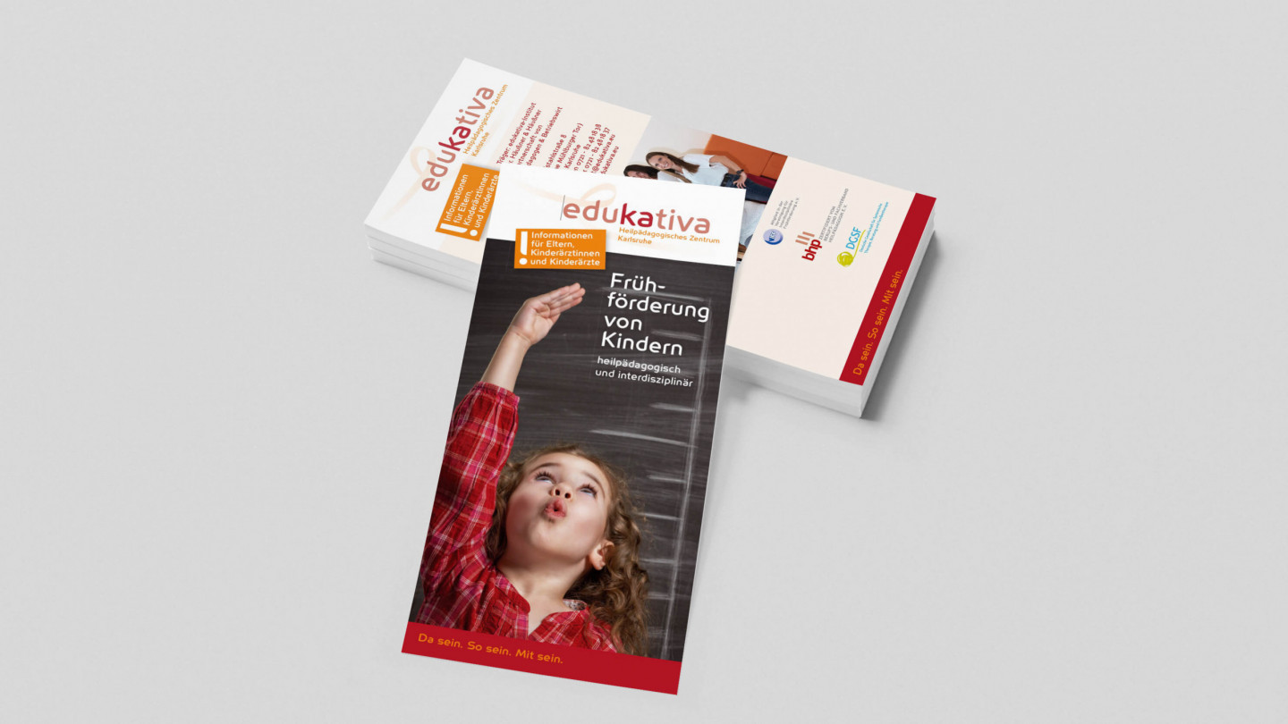 Ein Stapel edukativa-Flyer zur Frühförderung zeigt ein Kind, das neugierig nach oben schaut.